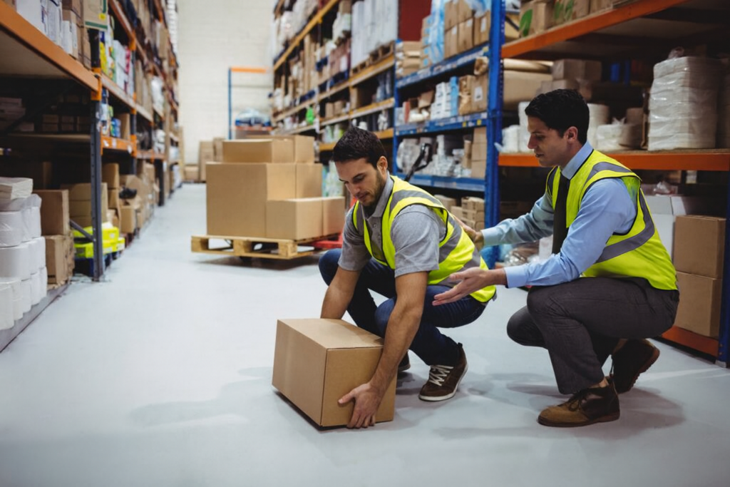 Warehouse staff working together to handle stock safely